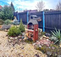The garden of a family house in Unín with a fireplace and a gravel area.