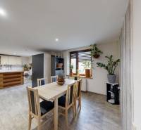 Kitchen and dining room with wood-patterned flooring in a family house, houseplants.