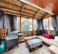 In the family house, there is a covered terrace with a grill, a windbreak, and garden furniture.