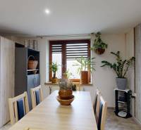 Dining room in a family house with wooden furniture and houseplants.