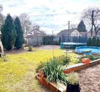A garden in a family house in Unín with a slide, trampoline, and pool.