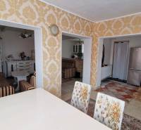 Interior of a family house with rich patterns, a kitchen, and a seating area.