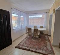 A bright dining room with large windows in a family house.