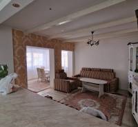 Living room in a family house with striped sofas, a table, and a decorative wall.