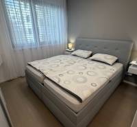 Bedroom in a two-room apartment with a bed, nightstands, and a floor with a wood decor.