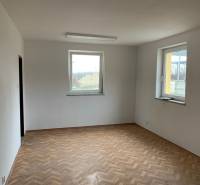 An empty room with two windows and a wooden decor floor in warehouses and halls.