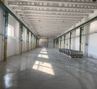 Interior of a warehouse and hall with steel coils on a concrete floor.