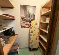 Storage space with shelves and an ironing board in a 3-room apartment.