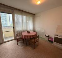 A kitchen in a 3-room apartment with a dining table, electric stove, and access to a balcony.
