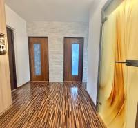 Interior of a 4-room apartment with a wooden decor floor and decorative doors.