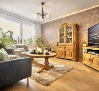 Living room with a sofa, wooden furniture, and a floor with a wooden decor in a 4-room apartment.