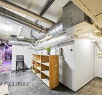 A space in a building with lots of piping, shelves, and a colorful graffiti wall.