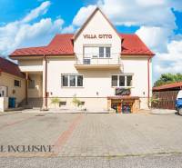 A building with a red roof and designated parking in Dunajská Streda.