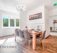 A dining room with a chandelier and wood-patterned flooring in a building.