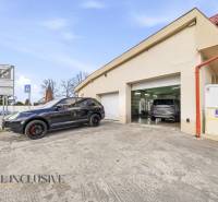 A building in Dunajská Streda with cars in front of garages and traffic signs.