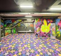 The interior of a building with graffiti on the walls and a colorful carpet with stars.
