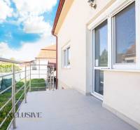 A building in Dunajská Streda with a terrace and railing, sky with clouds.