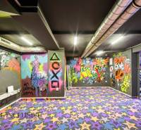 The interior of a building with colorful graffiti and a patterned carpet.