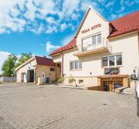 Building in Villa Otto in Dunajská Streda with a red roof and a paved parking lot.