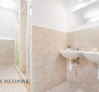 Bathroom with two sinks and a shower, decorative tiles and a mirror in the building.