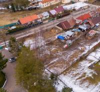 Aerial view of snow-covered gardens in Nálepkovo with multi-colored roofs and construction sites.
