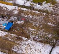 Gardens in Nálepkovo with icy snow, older shelters, and fences in winter.