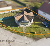 Land for sale for residential purposes in Zemianska Olča with a house and a grassed area.