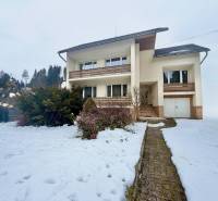The family house in Čadečka in Čadca is surrounded by a snowy garden and low-maintenance shrubs.
