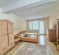 A bedroom in a family house with wooden furniture and a floor with a wooden decor.