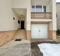 A family house in Čadečka in Čadca with stairs and a garage, remnants of snow on the driveway.