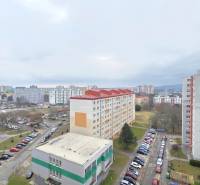 View of the housing estate in Bratislava-Petržalka on Holíčska Street with parking lots and apartment buildings.