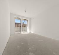 An empty room with a large window in a 4-room apartment, light walls and a window to the terrace.