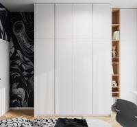 White built-in wardrobe with decorative black wallpaper and wooden decor flooring in a 4-room apartment.