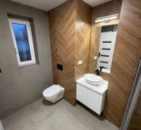 Bathroom in a 3-room apartment with tiles and a wooden decor floor.