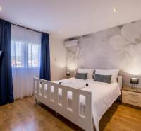 Bright bedroom with TV, air conditioning, and wood-patterned flooring in the villa.