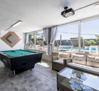 Interior of a villa with a billiard table and a view of the pool.