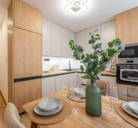 Kitchen in a 2-room apartment with a dining table and a wooden decor floor.