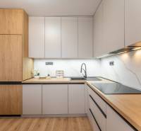 Corner kitchen in a 2-room apartment with modern elements and a wooden decor floor.