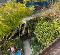 A garden at the cottage in Vyšné Opátske with a pathway, greenery, and garden decor.