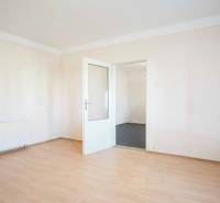 A room in a family house with white walls and a wooden decor floor.