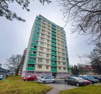 High-rise residential building on Trieda SNP in Banská Bystrica with a parking lot in the foreground.
