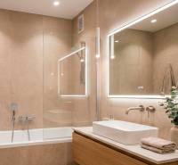 Bathroom in a 2-room apartment with a bathtub, mirror, and light tiles.