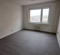 A room with a wooden decor floor in a studio apartment, an empty room with a window.