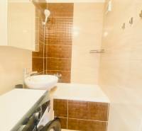 Bathroom in a 2-room apartment with a sink, bathtub, and washing machine.