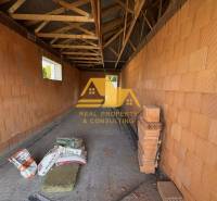 Construction of a family house on a street in Nové Zámky with brick walls and a beam ceiling.
