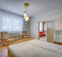 A bedroom in a family house with light wooden furniture and comfortable chairs.