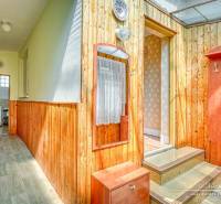Wooden interior with a hallway and entrance in a family house with light walls.