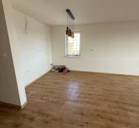 A two-room apartment with a wooden decor floor and pendant lights.