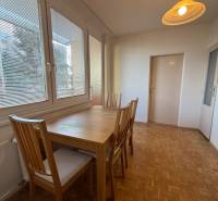 Dining room with a table and chairs in a 3-room apartment, floor with wood decor.