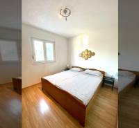 Bedroom in a family house with a double bed and a wooden decor floor.